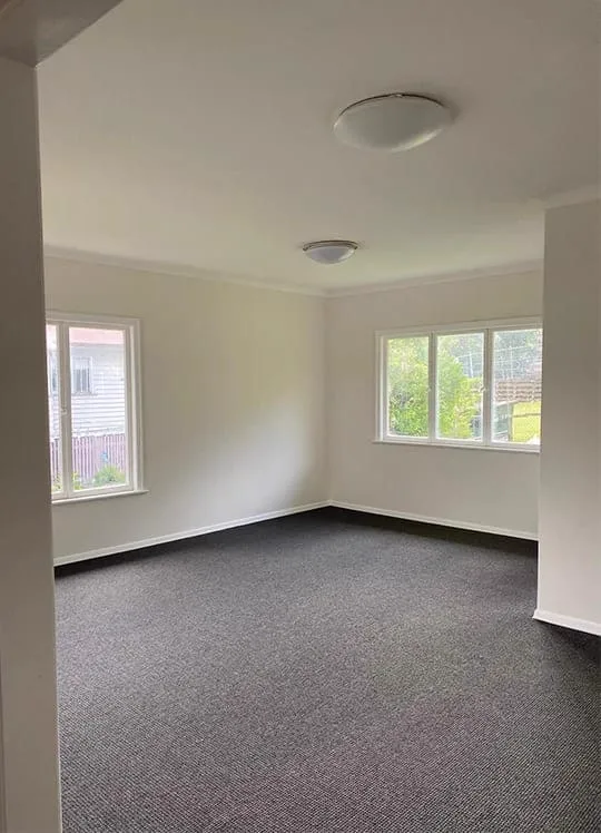 Empty bedroom with dark grey carpet laid wall to wall and finished neatly at the skirting